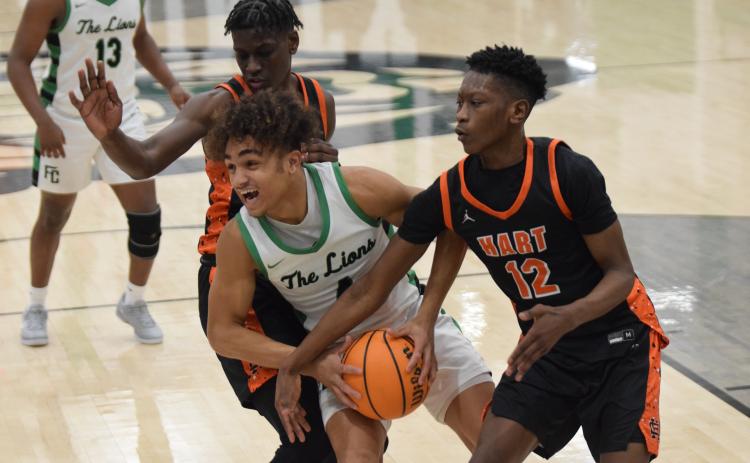 Nava Ware splits a pair of Hart County defenders during action Tuesday in Carnesville against the Bulldogs. (Photo by Scoggins)