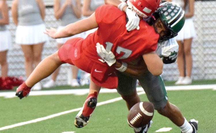 Franklin County High School Lion Nava Ware decleats a Madison County quarterback and causes a fumble during Friday’s scrimmage game in Danielsville.