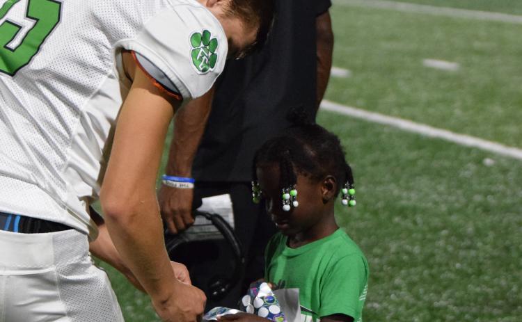 Ayden Brock, daughter of  Franklin County Lions Assistant Coach Deon Brock, handed out congratulatory stickers to the Lions Friday after the team defeated Chestatee 14-7 in overtime in the first contest of the season.