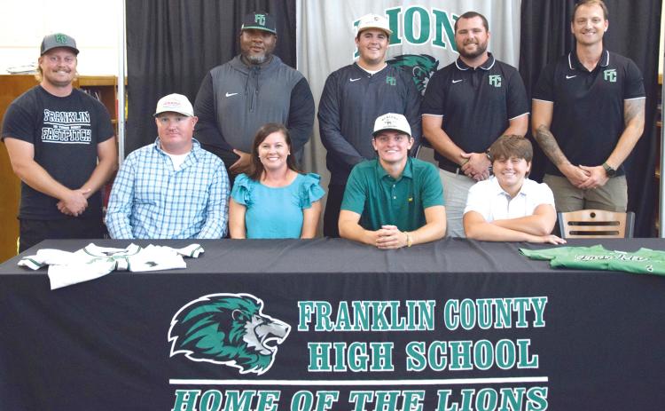 Joining Cade Gibson to celebrate his signing of a baseball scholarship to East Georgia State College are (front, from left) dad Brad Gibson, mother Rebekah Gibson, Cade, brother Nolan Gibson, (back) coaches Ty Tipton, Demond Rivers, Duncan Beasley, Head Coach Ryan Phillips and Drew Phillip. (Photo by Shane Scoggins)