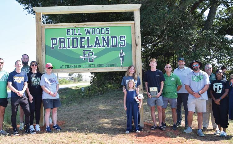 Members of the Wood family were joined Thursday by Franklin County School System officials and cross-country and track coaches for the dedication of the Bill Woods Pridelands Cross Country Course on High Road in Carnesville. (Photo by Shane Scoggins)