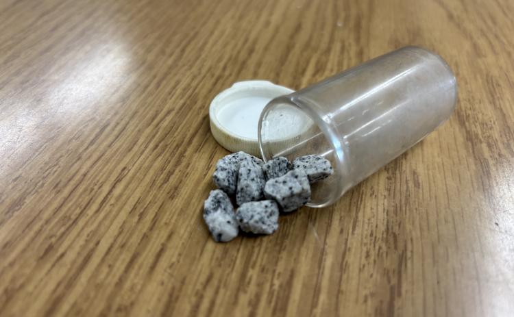 A small pill bottle containing eight pieces of gravel serve as a reminder that in local journalism, you will never see it all.