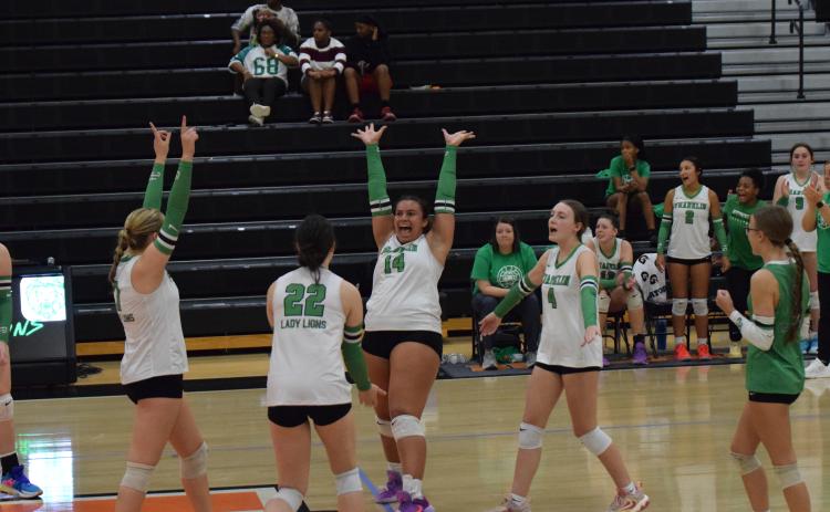 Lady Lion Kallie Thrift (No. 14) celebrates with teammates Callie Frady and Avery Burton after winning a point in Franklin County’s Region 8AA semifinal win over Hart County last week. The win qualified Franklin for the state playoffs for the first time in school history. (Photo by Shane Scoggins)