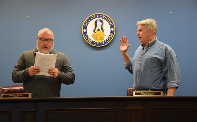 Royston Mayor Jason Phillips (left), presiding over his first meeting as mayor, swore in new Council Member Bob Adamson (right) as well as re-elected members Matt Fields and David Pressley (not pictured) during the Royston City Council’s meeting Tuesday at Royston City Hall. (Photo by Shane Scoggins)