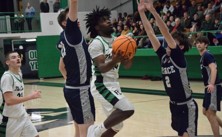Jeremiah Mayfield goes up for a layup between two Prince Avenue defenders in Franklin County’s home victory Friday. (Photo by Shane Scoggins)