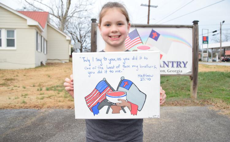 Posie Harris shows off an original painting of The Rainbow Pantry logo that she donated to the charity, along with proceeds from an auction of her other artwork. (Photo by Shane Scoggins)