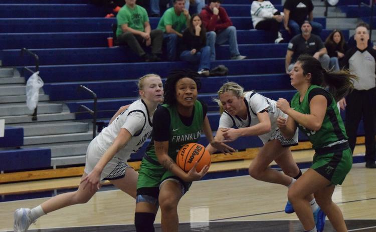 Senior Ta’Kiah Winkfield gets by two Coahulla Creek defenders on her way to the basket in a Sweet 16 game in Dalton Friday. (Photo by Shane Scoggins)