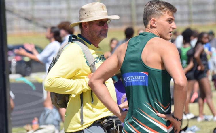 Coach Blackie Swart (left) and Dian Huisemen of Rustenburg High School in South Africa stand at the triple jump pit during Saturday’s John Scott Hartness Invitational track and field meet at Franklin County High School. (Photo by Shane Scoggins)
