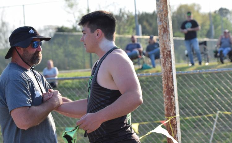 Coach Clint Tanner (left) congratulates Candler Stone after Stone broke the school record for shot put Thursday at FCHS. Tanner, who coaches Stone, set the previous record in 1999. (Photo by Shane Scoggins)