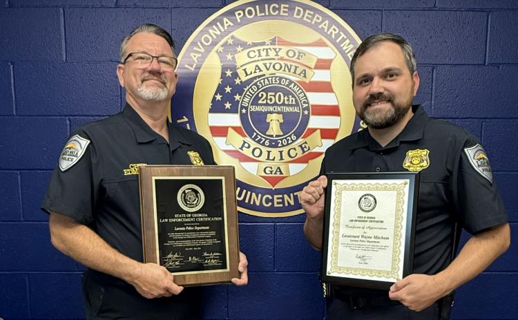 Lavonia Police Chief Shane Edmisten (left) and State Certification Manager Lt. Wayne Mitchum (right) show off the department’s recertification plaques the department earned.
