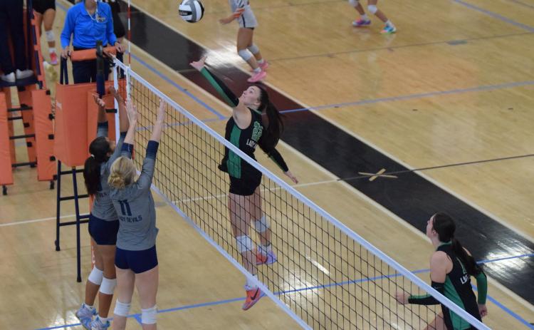 Senior Lady Lion Avery Burton jumps to push the ball across the net over two Elbert County defenders Tuesday in Region 8AAA action at Hart County High School. (Photo by Shane Scoggins)