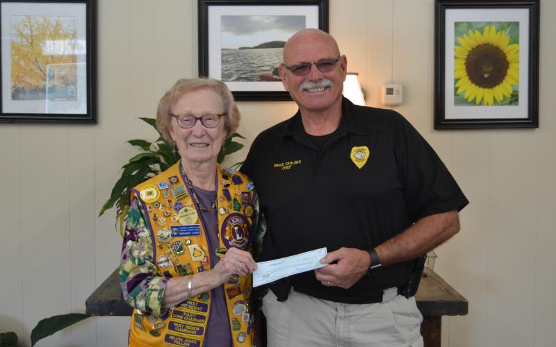 The Lavonia Lions Club, in conjunction with the Lavonia Police Department, will sponsor National Night Out  today beginning at 5 p.m. in downtown Lavonia. Pictured is Lavonia Lions Club member Margaret Ayers presenting Lavonia Police Chief Bruce Carlisle with a check for the event. (Photo by Eberhardt)