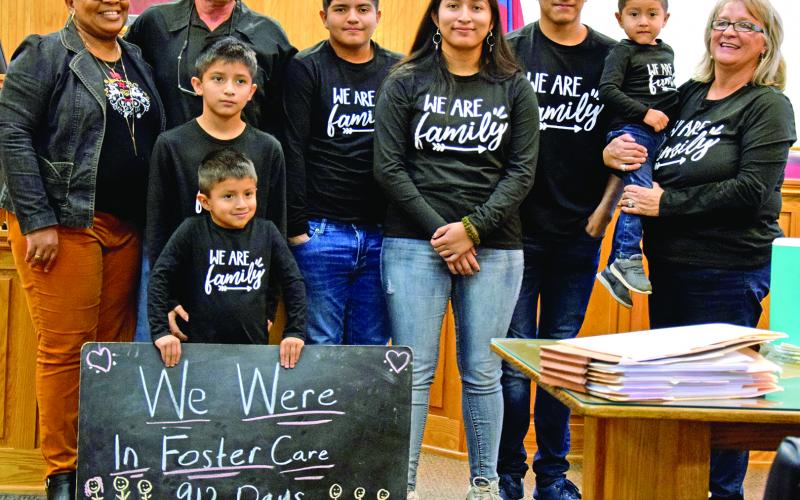 Steve and Angela Whidby completed the adoption Thursday of six siblings who had been in foster care with the family since 2017. Pictured in the courtroom at the Franklin County Courthouse are (front) Angel (holding sign) Felipe, (back) Case Manager Stephanie Tate, Steve Whidby, Edwin, Jennifer, Jose, Emmanuel and Angela Whidby. It was the largest single adoption in county history. (Photo by Scoggins)
