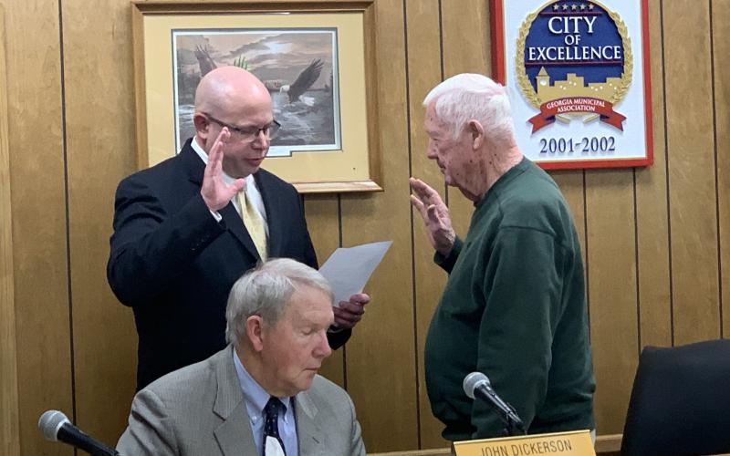Lavonia Mayor Ralph Owens (right) swears in new Councilmember Michael Schulman (left) during Owens’ final meeting as mayor. City Attorney John Dickerson looks on.