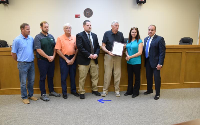 Franklin County Commissioners (from left) Eddie Wester, Ryan Swails, Robert Franklin, Jason Macomson and Chairman Thomas Bridges present Jennifer Garner, widow of Deputy William “Bill” Garner, with a plaque containing a resolution in her husband’s honor. Deputy Garner was killed July 19 in the line of duty. (Photo by Scoggins)