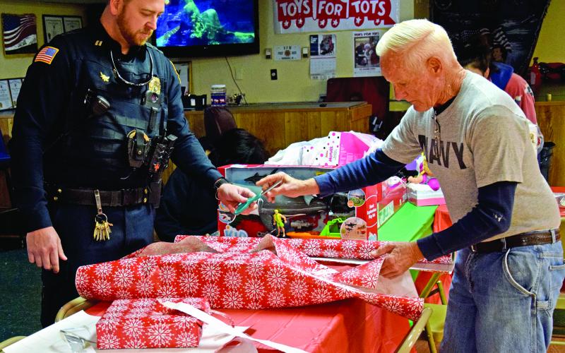 Lavonia Officer Blake Andrews and Lavonia VFW Post Commander Jim “Chief” Bright wrap presents during Saturday’s Shop with a Cop event sponsored by the Northeast Georgia chapter of the Fraternal Order of Police. (Photos by Scoggins)