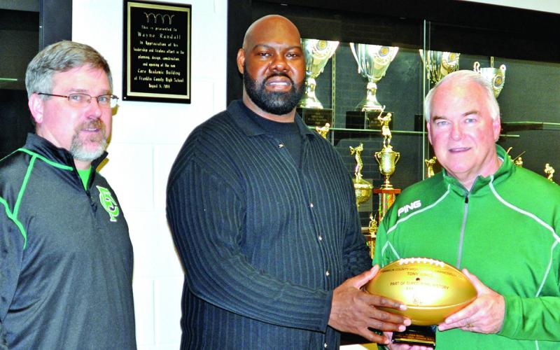 Tony Jones (center) presented a commemorative football in 2016 to then Franklin County High School Principal Brad Roberts (left) and Athletic Director Jeff Davis on the occasion of the 50th Super Bowl. The footballs were presented to the high schools of each player who played in a Super Bowl. Jones was on two Super Bowl champion Denver Broncos teams.