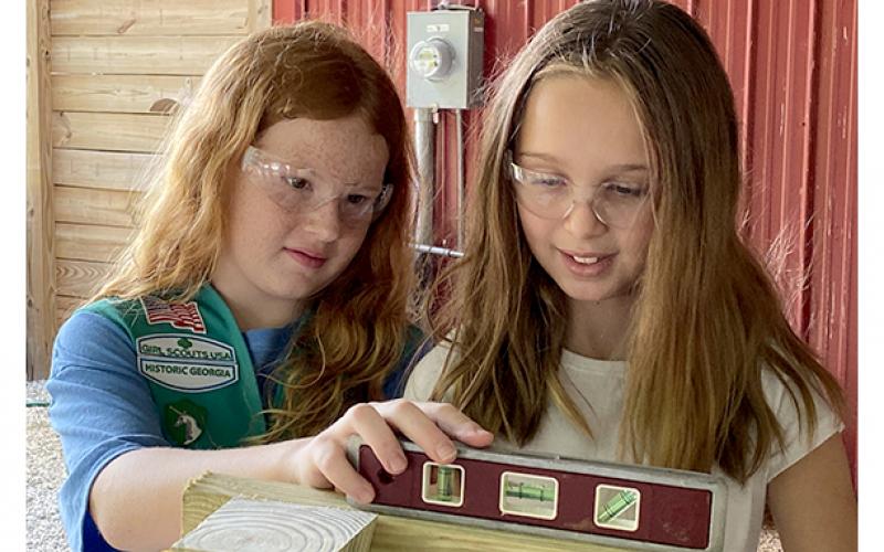 Girl Scout Juniors Kate Graham and Charlie Smith check to make sure the bench they are building is level.