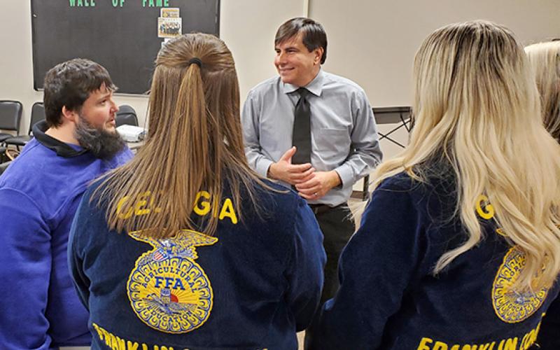 Agriculture teacher Trey Harris and FFA students Chloe Pulliam, MaCaylee Childs, and Sarah Pulliam talk with Brent Lemond about the FFA program during a meet and greet after the Franklin County Board of Education meeting Thursday night. (Photo by Sinclair)