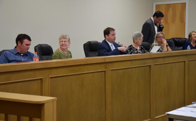 Franklin County Board of Elections and Registration members (from left) Roman Strickland, Alice Black, Chairman Doug Kidd, Sherry MacDonald and Angela Whidby (with County Attorney Bubba Samuels and Elections Superintendent Gina Kesler) prepare to listen to tesimony following a break in a hearing Wednesday on a challenge to the residency of Lee and Sheena Strickland.