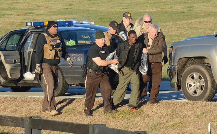 Hart County Sheriff's deputy David Cleveland (left) and Sheriff Mike Cleveland (right) escort murder suspect Larrendrick Rashad Tabor after his arrest Tuesday near South Hart Elementary School in Hart County. (Photo courtesy of The Hartwell Sun)