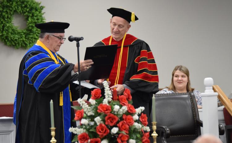 Dr. Ronnie Simpson of Macedonia Bible College presents Dr. Dan Bailey with his diploma during a ceremony Saturday at Abundant Life Baptist Church in Hartwell, where Bailey is a member and Sunday School teacher. (Photo by Scoggins)